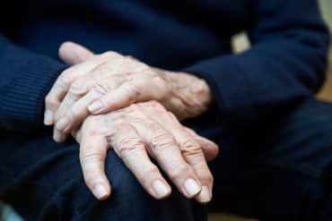 Une personne atteinte par la maladie de Parkinson tente de limiter les tremblements de sa main