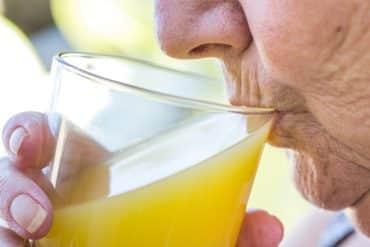 Une personne âgée boit pour éviter la déshydratation