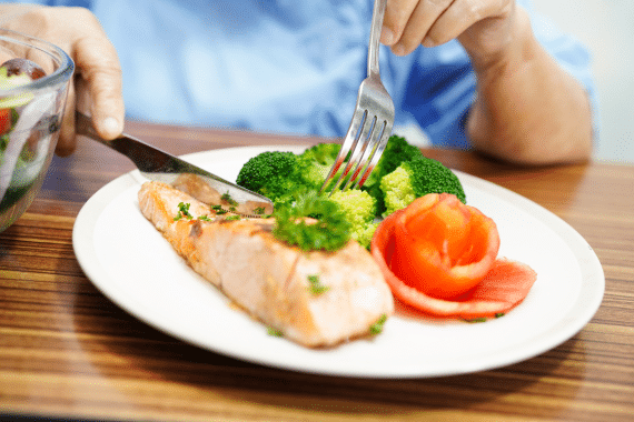 Une personne âgée déguste un repas composé d'aliments riches en protéines