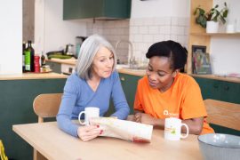 Une aide à domicile accompagne et rend service à une personne atteinte de la maladie d'alzheimer