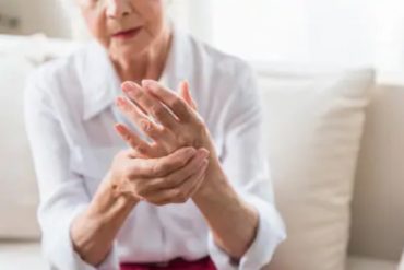 Une personne âgée touche la partie de sa main souffrant d'arthrite