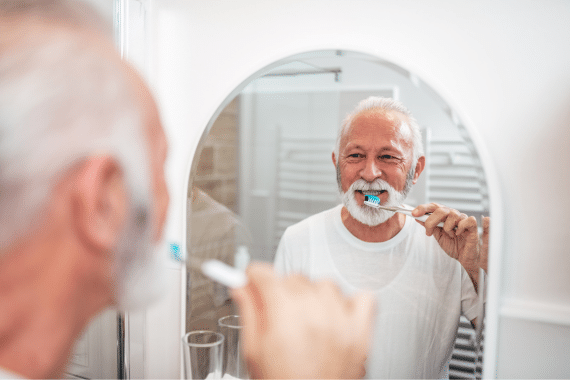 Une personne âgée entretient son hygiène dentaire en se brossant les dents