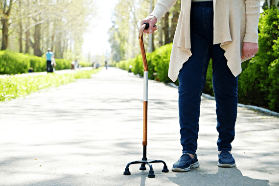 Une personne âgée utilise une canne de marche tripode pour se déplacer