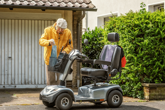 Une personne âgée s'apprête à utiliser son scooter pmr